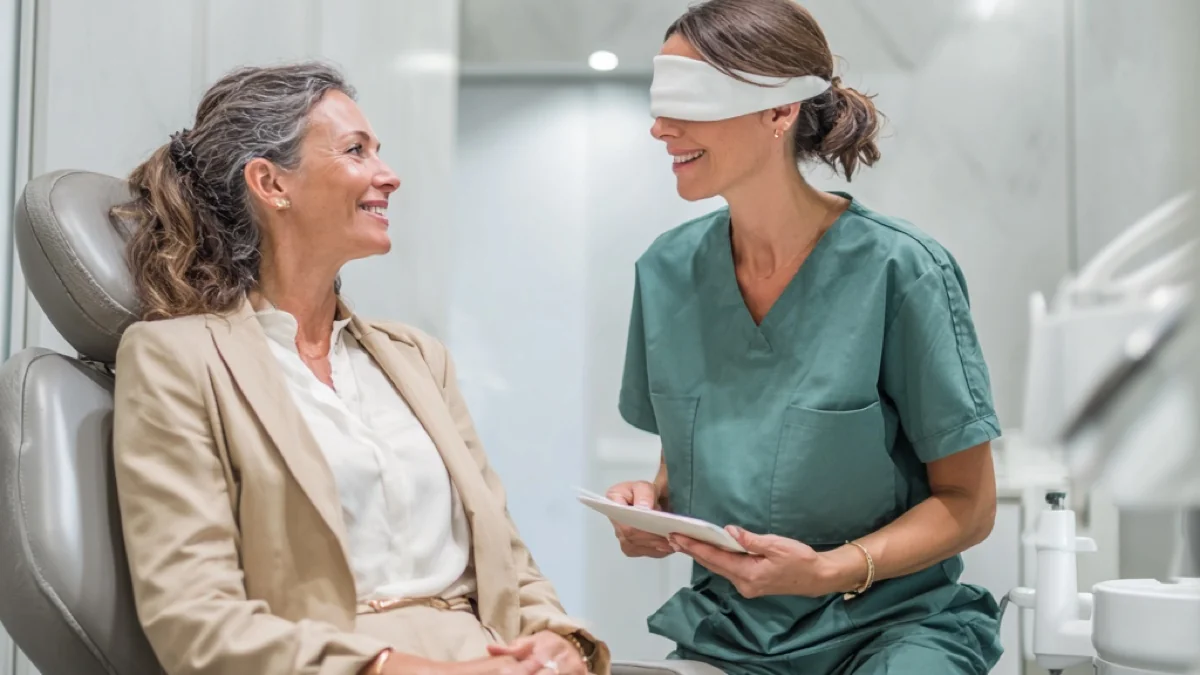 Practitioner with a blindfold consulting a client — a visual metaphor for the aesthetic industry's blind spots
